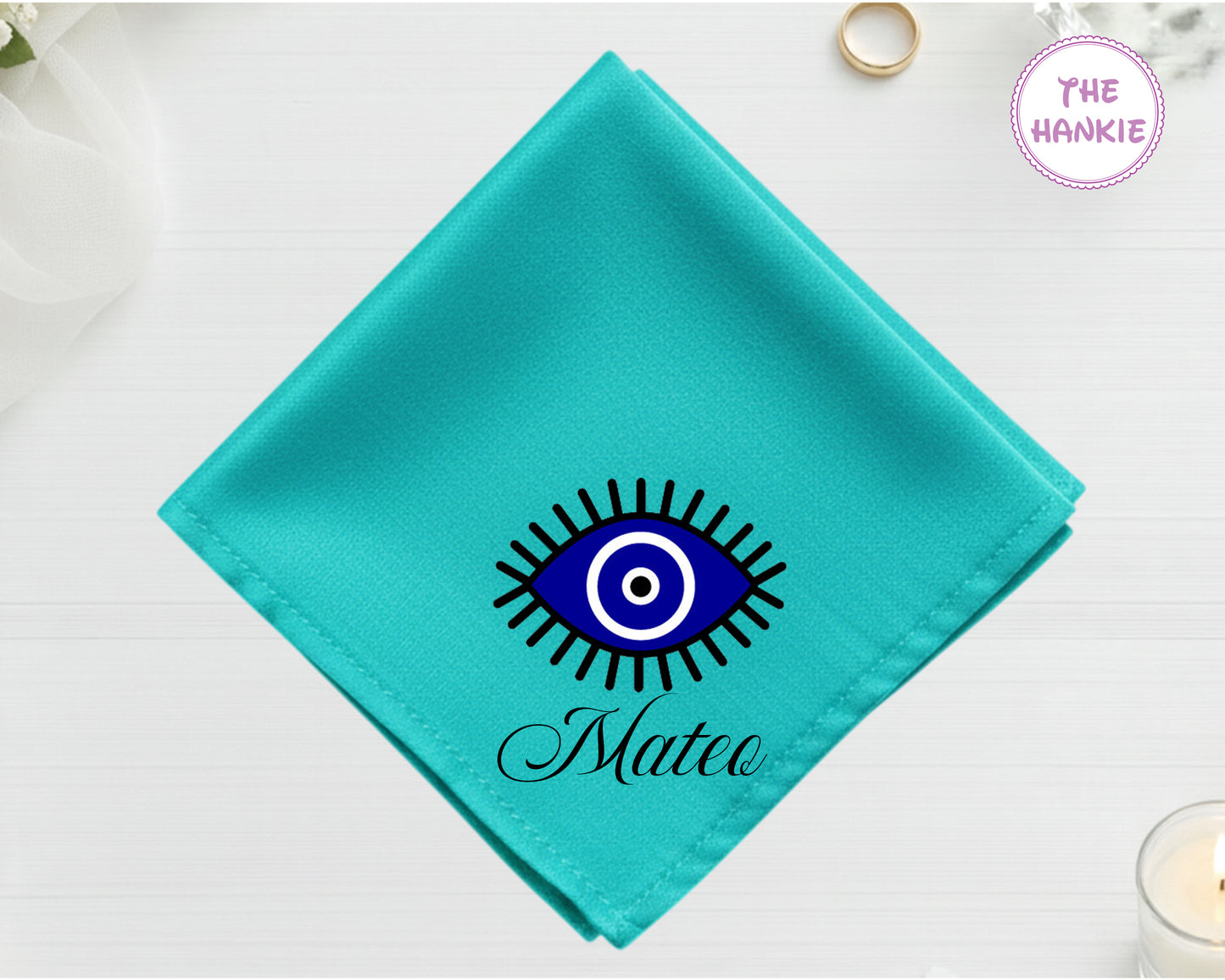 A vibrant turquoise cotton handkerchief customized with "Mateo" and a classic blue and white circular Nazar evil eye design.