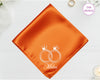 A radiant sunset orange high-lustre satin pocket square featuring the name "Miles" and white embroidery of two interlocking wedding bands topped with crowns.