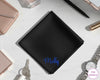 A bespoke black cotton handkerchief showcasing the name "Molly" in a bright electric blue vinyl script on a marble surface.
