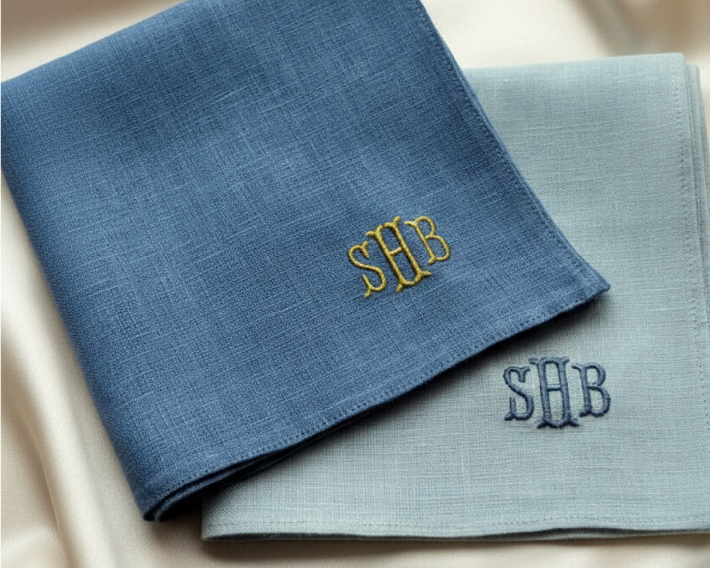 A pair of soft 100% cotton pocket squares in sky blue and white, each featuring a professionally embroidered custom monogram for a personalized formal look.