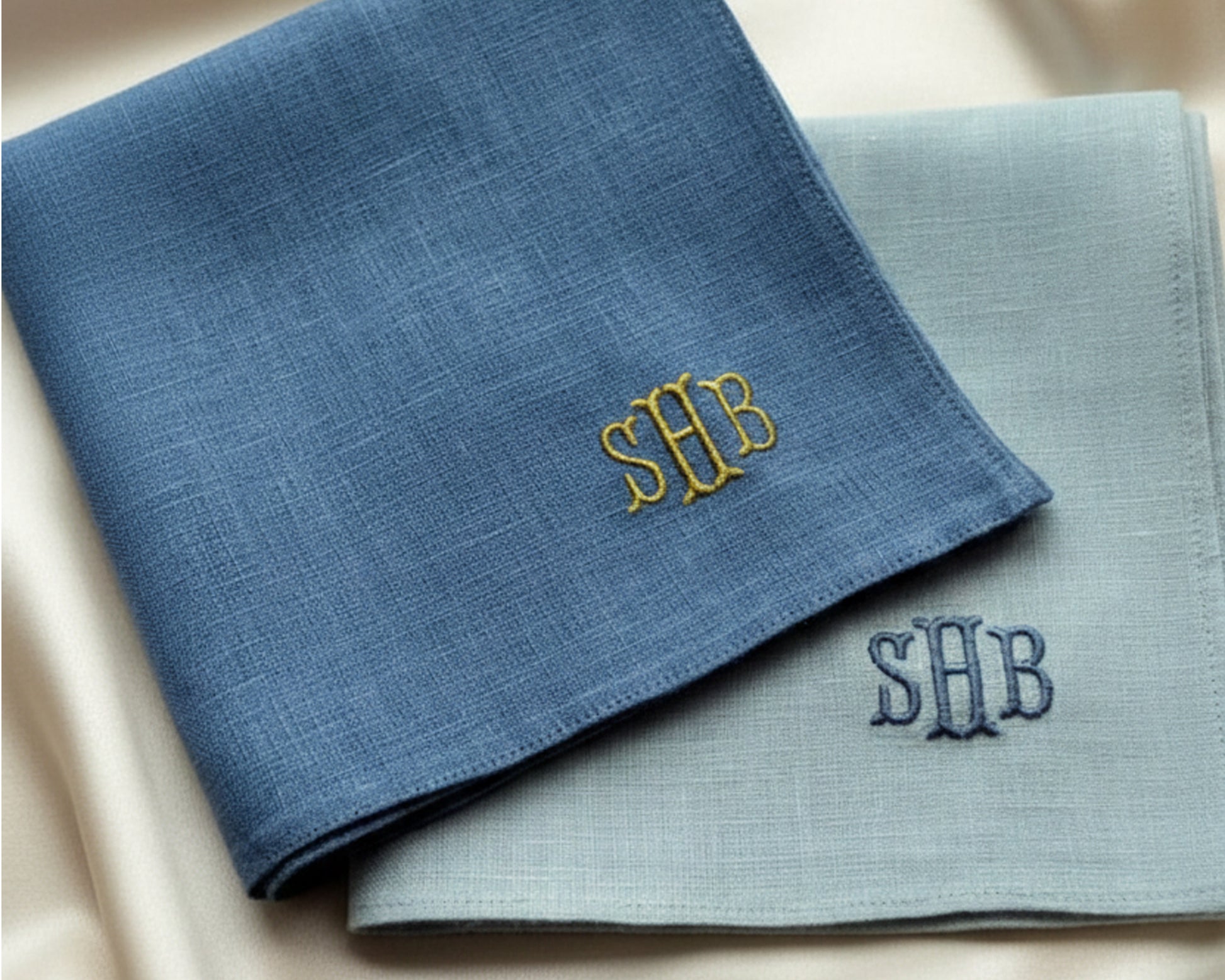 A pair of soft 100% cotton pocket squares in sky blue and white, each featuring a professionally embroidered custom monogram for a personalized formal look.