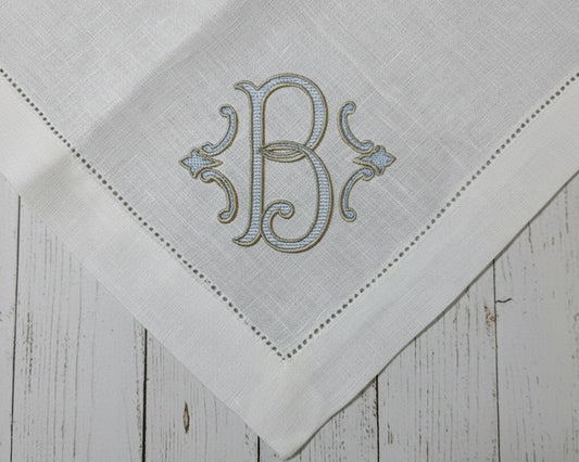 White linen napkin with elegant embroidered letter B monogram and hemstitch border