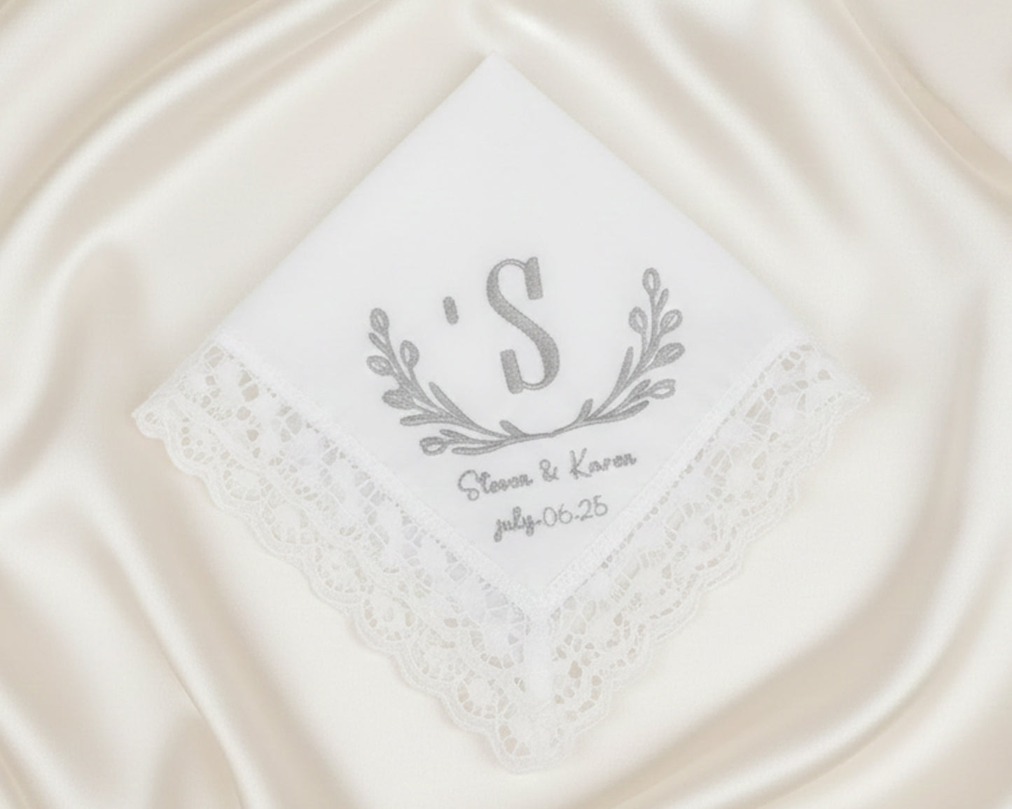 Small white cotton cocktail napkin with a navy blue embroidered frame and custom two-letter duogram