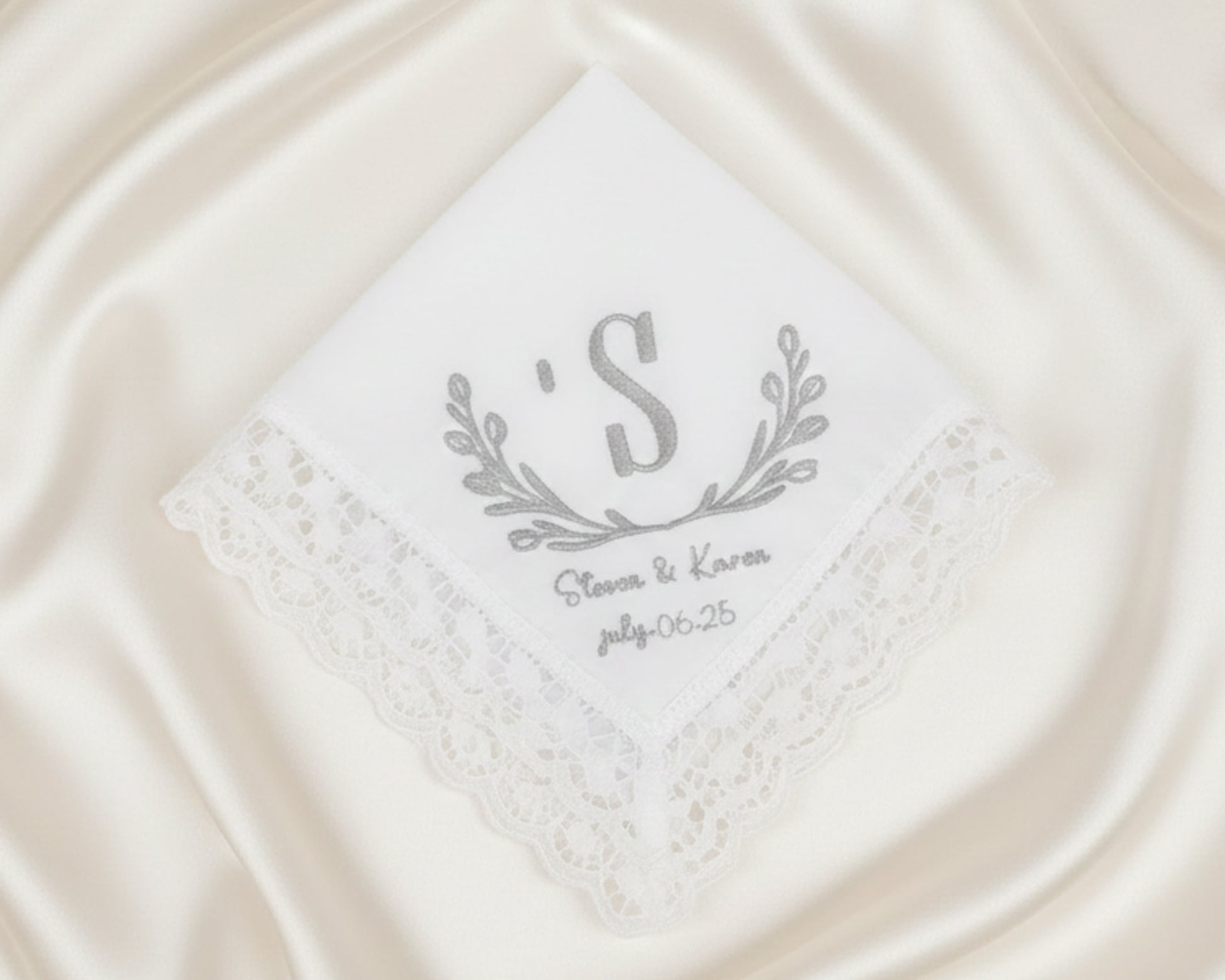 Small white cotton cocktail napkin with a navy blue embroidered frame and custom two-letter duogram