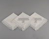 White cotton cocktail napkin with a navy blue embroidered border and a personalized two-letter duogram