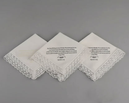 White cotton cocktail napkin with a navy blue embroidered border and a personalized two-letter duogram