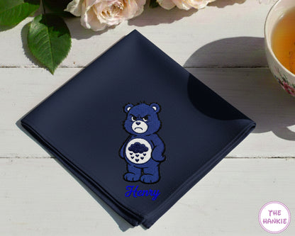 A luxurious navy blue satin handkerchief featuring the personalized script name "Noah" in purple alongside a detailed Harmony Bear embroidery.