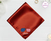 A burnished copper luxury satin handkerchief personalized with the name "Olivia" below an embroidered icon of sunglasses featuring the American flag.