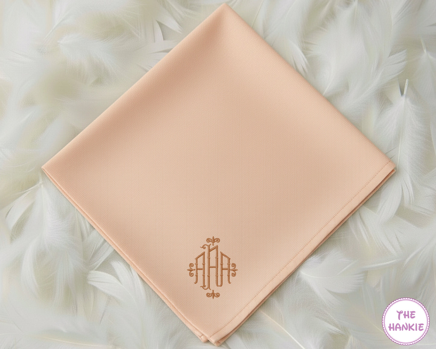 A soft peach-colored premium cotton handkerchief personalized with a sophisticated, classically styled tan monogram in the corner.