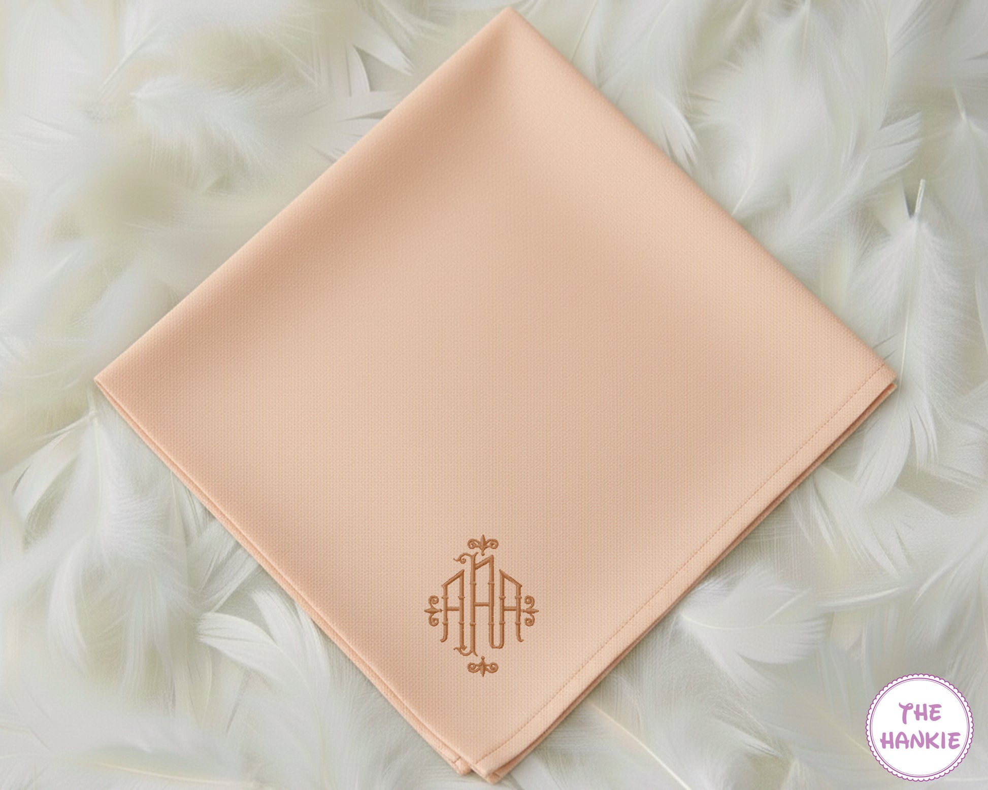 A soft peach-colored premium cotton handkerchief personalized with a sophisticated, classically styled tan monogram in the corner.