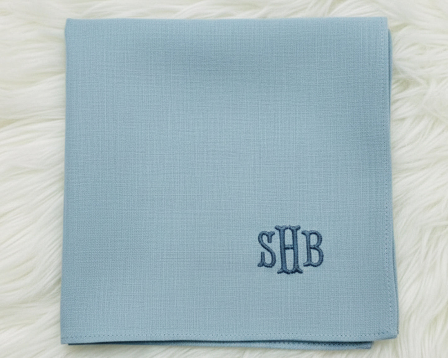 A variety of personalized 100% cotton handkerchiefs in navy, sky blue, and white, showcasing different thread color options for custom monogramming.