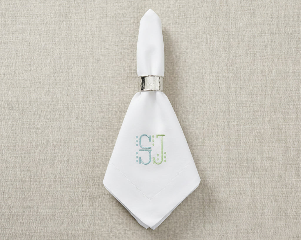 Personalized cotton table napkin with embroidered shield-style monogram design