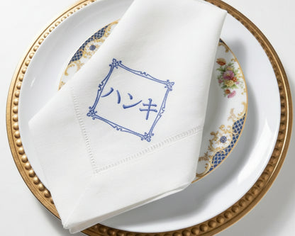 Personalized embroidered linen table napkin displayed on elegant wedding place setting