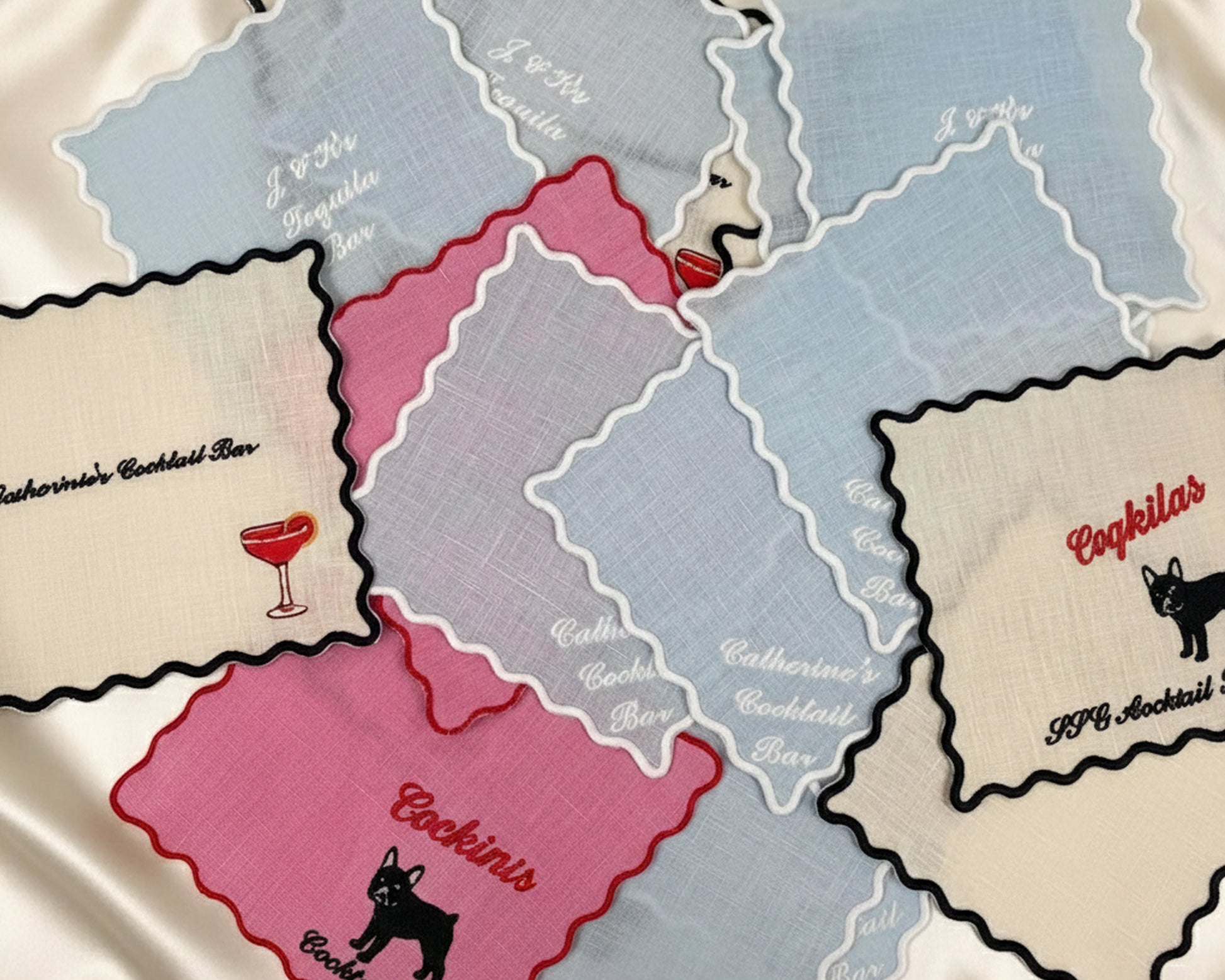 A guide showcasing four different embroidery layout designs for personalized scalloped linen cocktail napkins