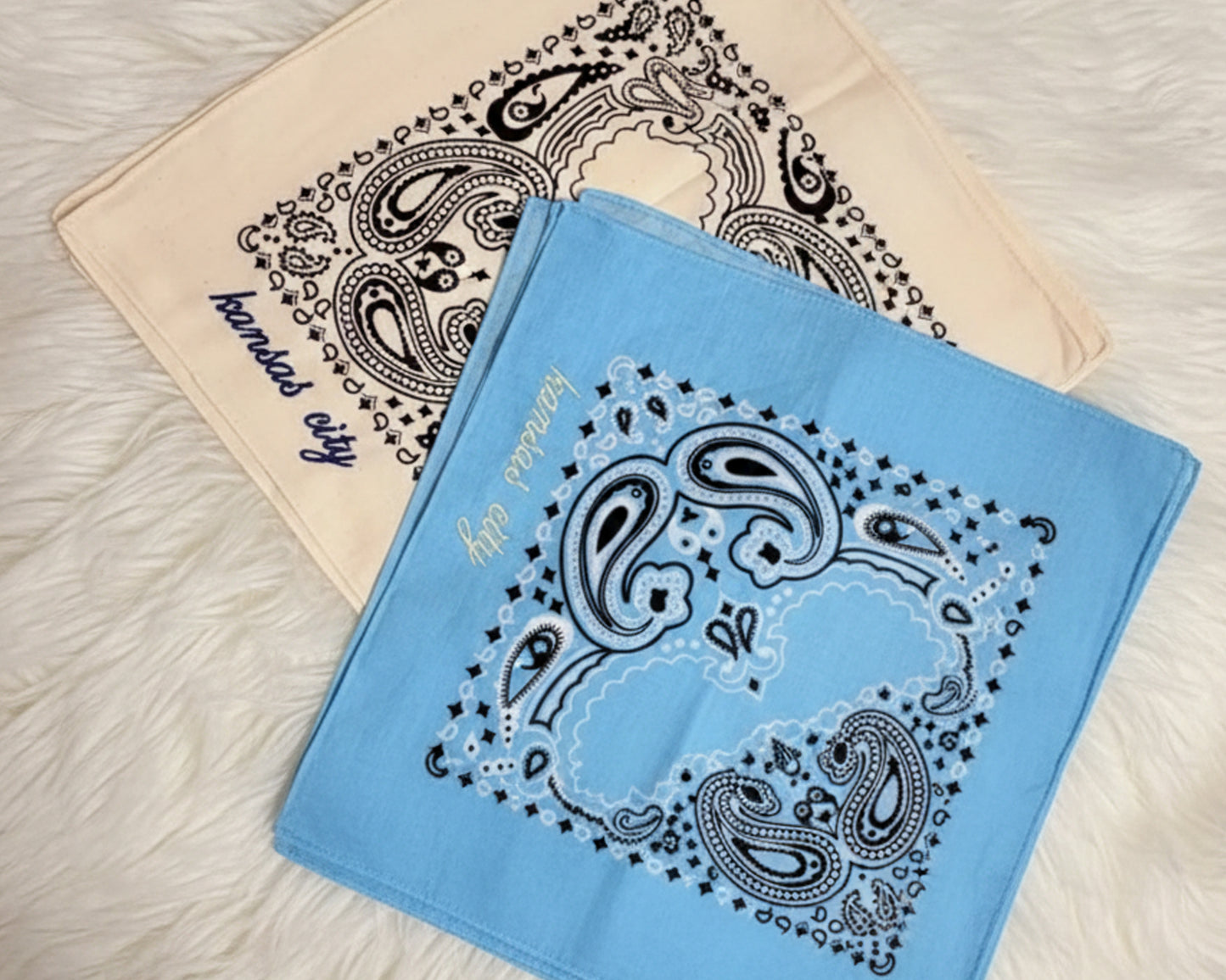 A person wearing a personalized green paisley bandana with white chain stitch embroidery tied around their neck in a western style.