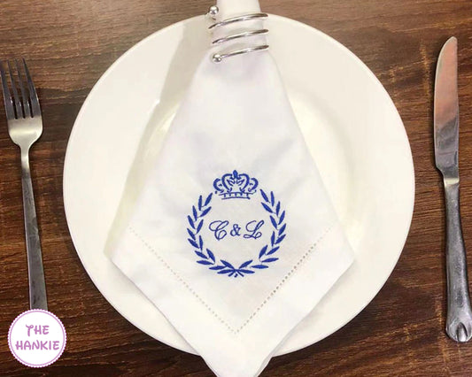 Personalized wedding monogram handkerchief with blue embroidery displayed on table setting