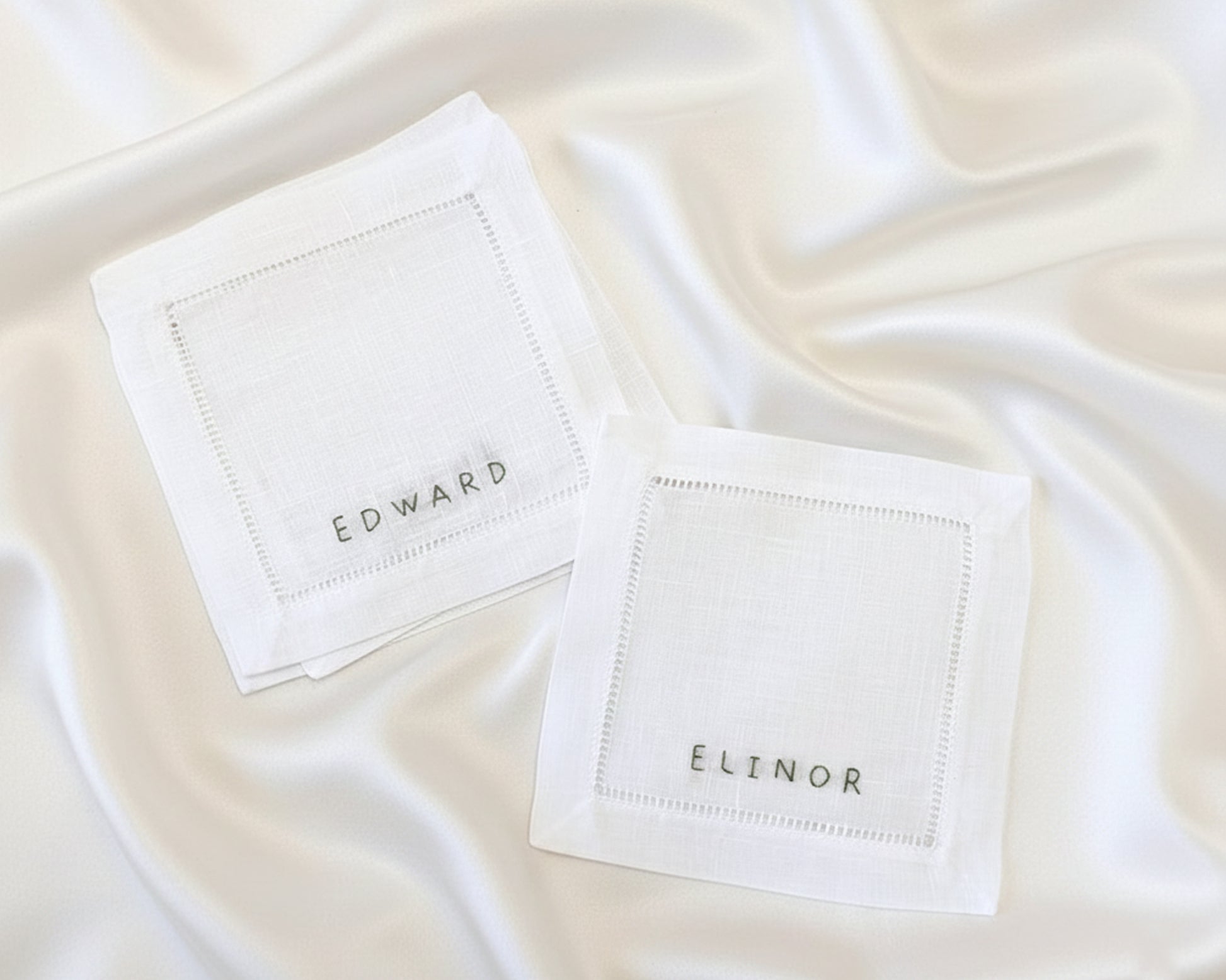 A natural-colored cotton linen napkin featuring the name "CHARLIE" in a high-density, uniform machine-embroidered script.