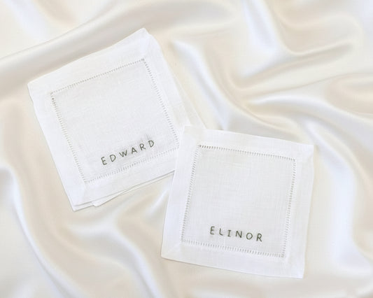 A natural-colored cotton linen napkin featuring the name "CHARLIE" in a high-density, uniform machine-embroidered script.