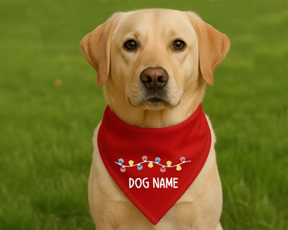 A golden yellow labrador wearing a classic merry red personalized holiday bandana featuring a festive colorful light string.