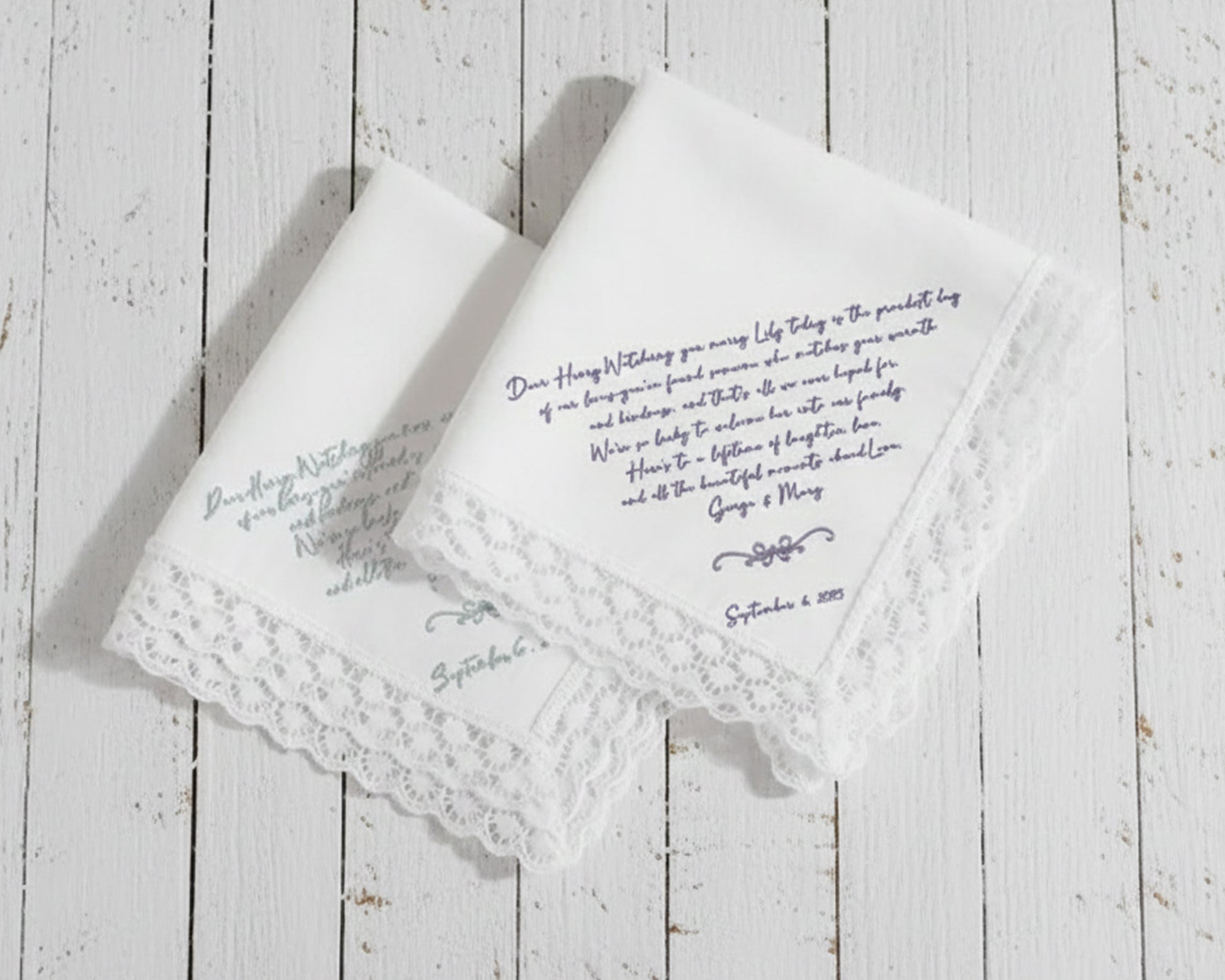 White cotton dinner napkin with an elegant sage green embroidered bow and personalized serif monogram