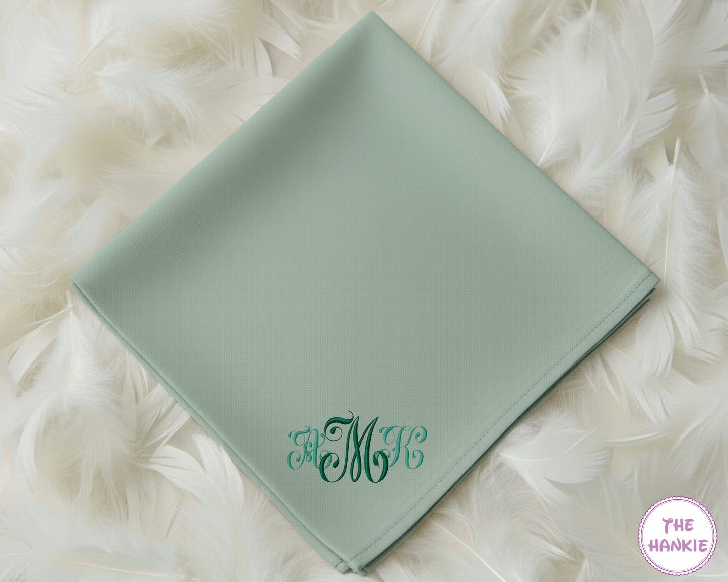 A sage green cotton handkerchief personalized with a sophisticated three-initial script monogram in a deep forest green embroidery.