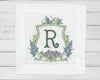 Close-up of a personalized white dinner napkin with a modern sage green 'AR' monogram