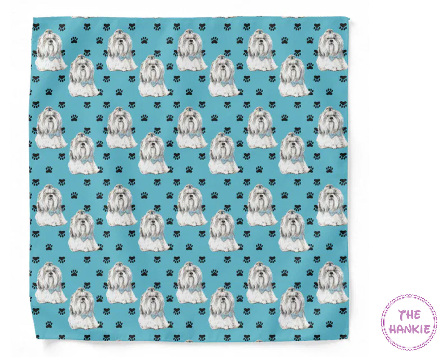Patterned towel with white dogs and black paw prints on a blue background, featuring 'The Hankie' brand.