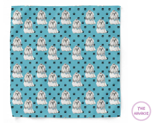 Patterned towel with white dogs and black paw prints on a blue background, featuring 'The Hankie' brand.