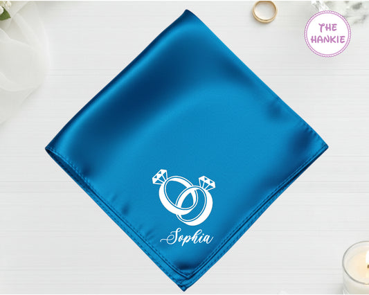 A brilliant electric azure blue satin handkerchief customized with "Sophia" and white embroidery of two interlocking diamond rings.