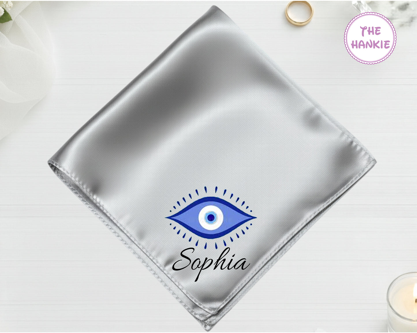 A radiant silver high-lustre satin pocket square customized with "Sophia" and a classic blue-and-white circular Nazar evil eye design.