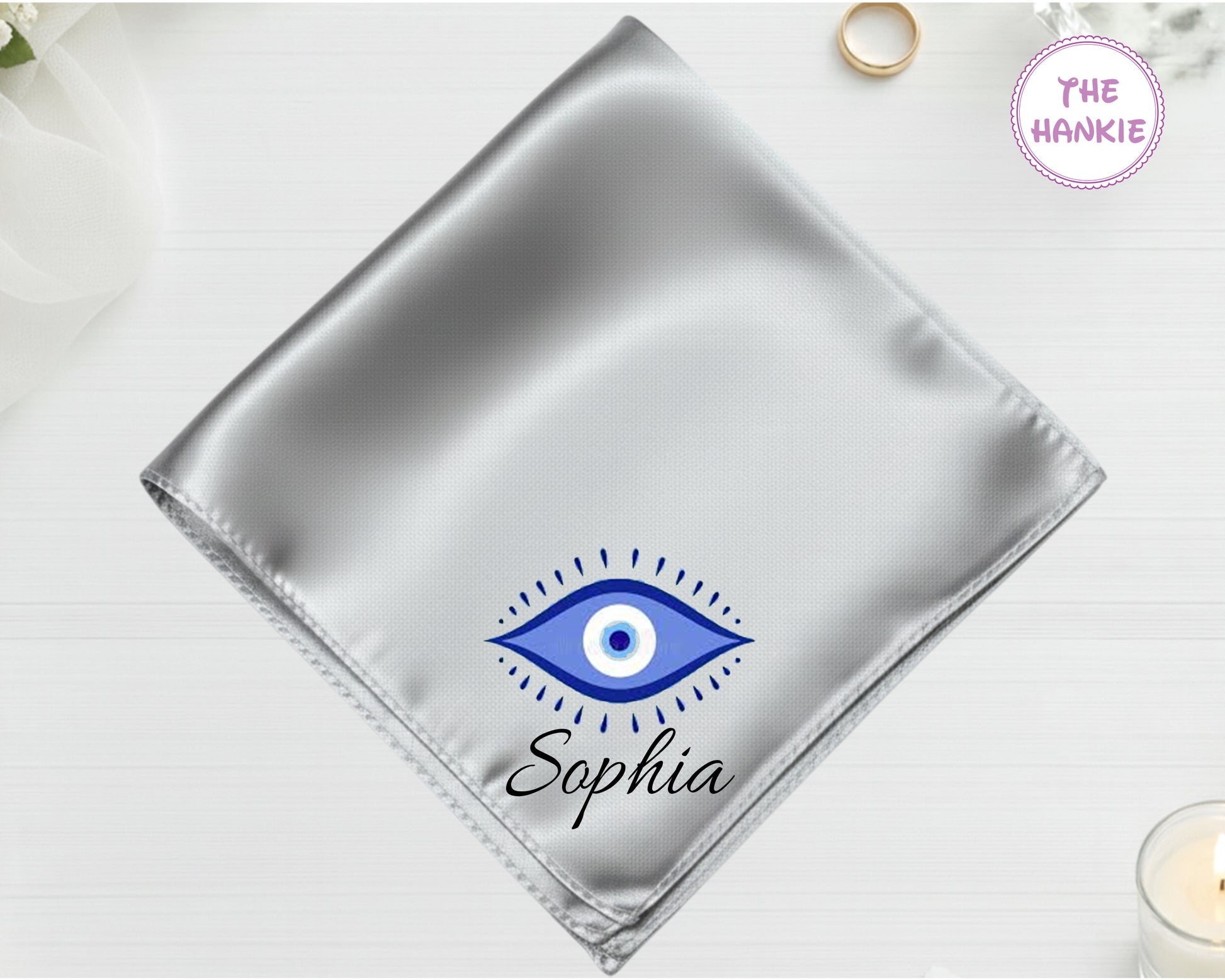 A radiant silver high-lustre satin pocket square customized with "Sophia" and a classic blue-and-white circular Nazar evil eye design.