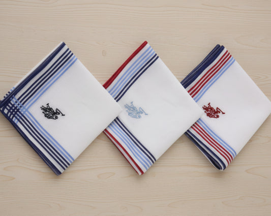 A set of three white U.S. Polo Assn. cotton handkerchiefs with navy, light blue, and red striped borders and embroidered logos.