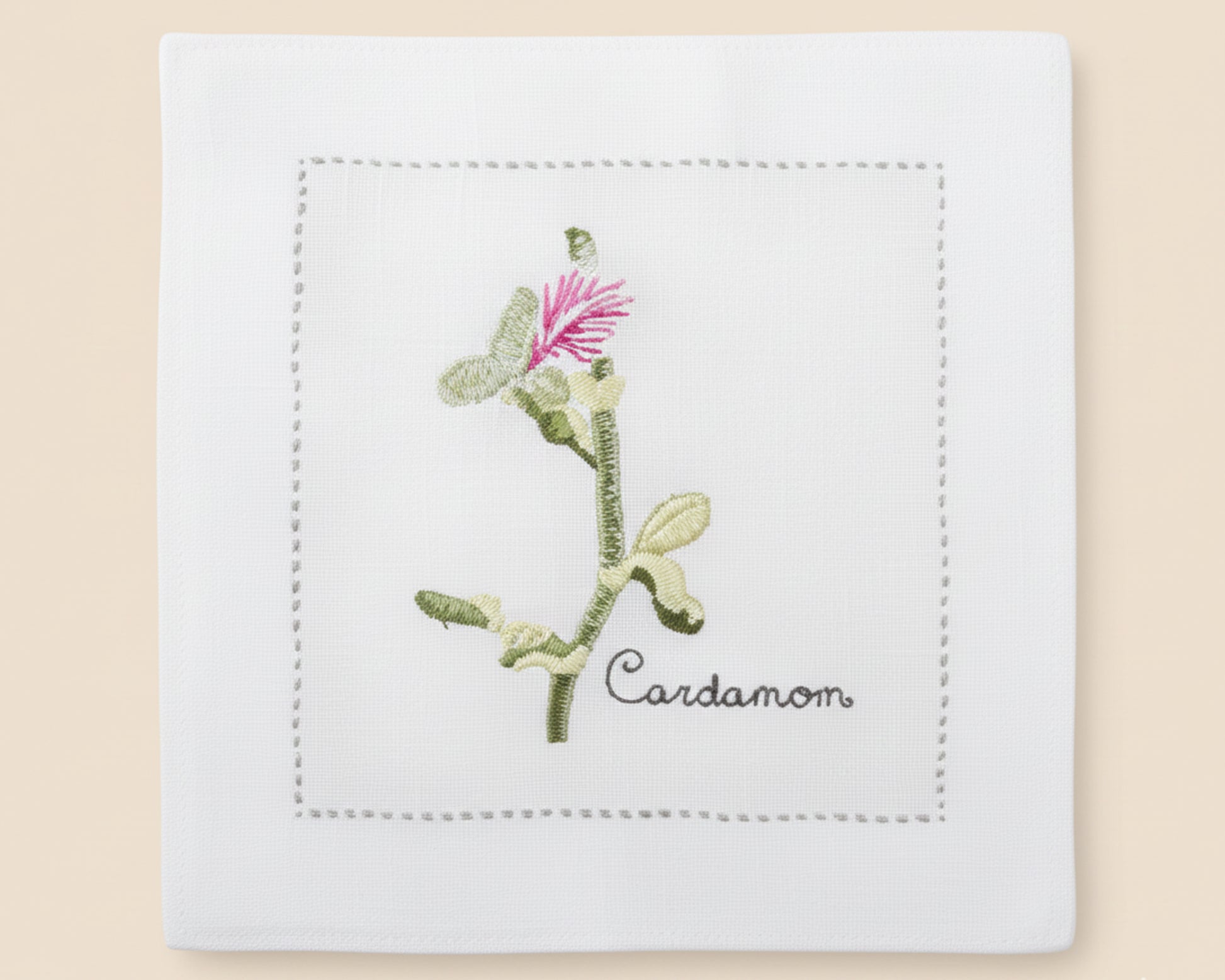 Single white linen cocktail napkin featuring a detailed white-flowered Anise sprig embroidery with a tailored hemstitch edge.