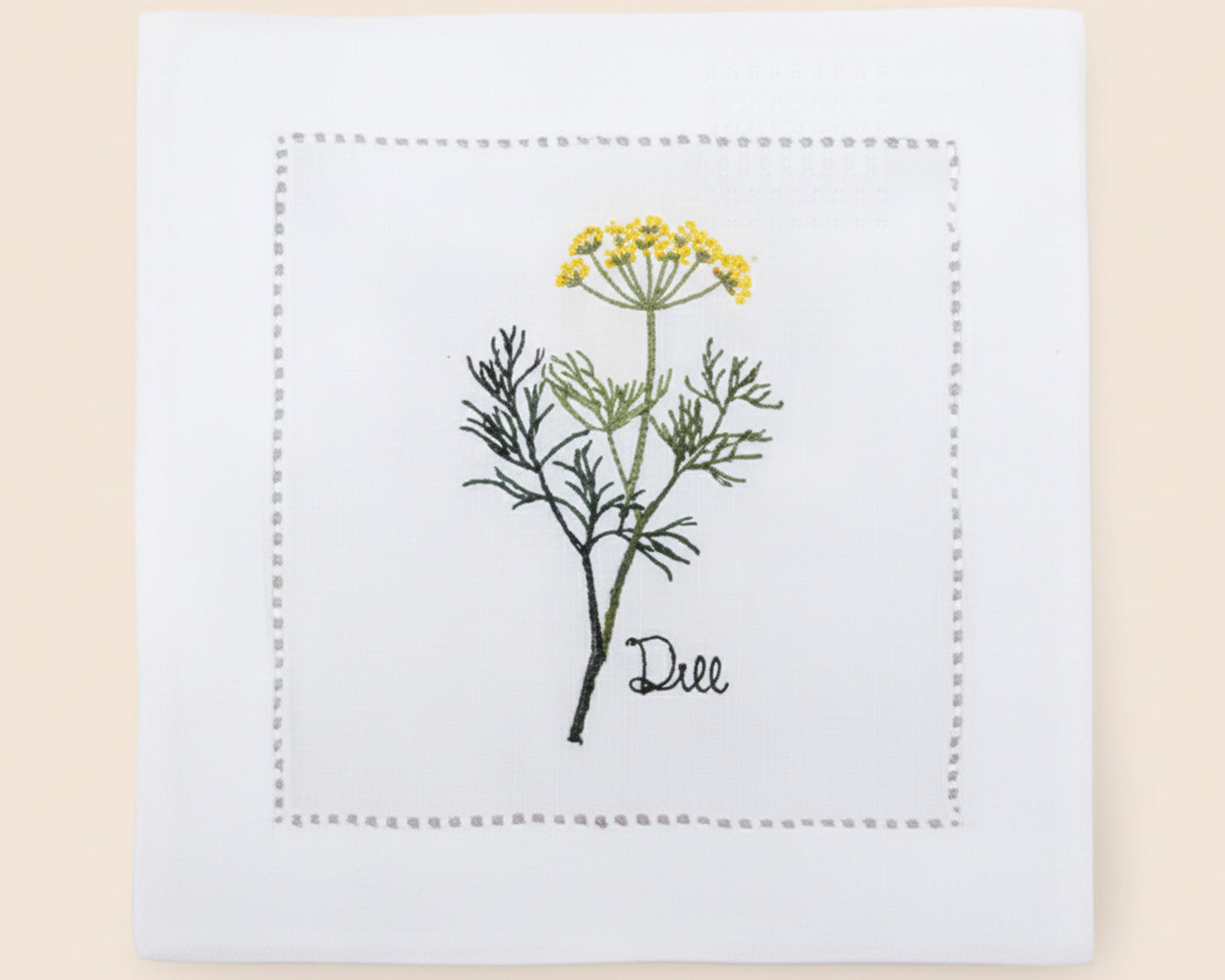 Single white linen cocktail napkin featuring a detailed pink-flowered Oregano herb embroidery with a classic hemstitch border.