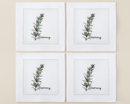 Single white linen cocktail napkin featuring a detailed purple-flowered Rosemary sprig embroidery with a hemstitch edge.