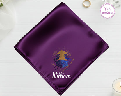 A deep plum luxury satin handkerchief personalized with the name "William" below a high-definition blue and gold vinyl Cancer zodiac icon.