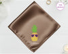 A burnished bronze satin handkerchief featuring "William" and a detailed pineapple embroidery wearing pink-lensed sunglasses.